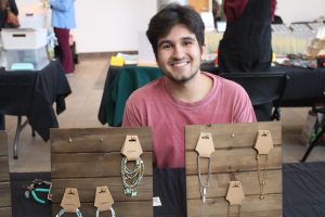 Student selling jewelry at Roger Williams University craft fair